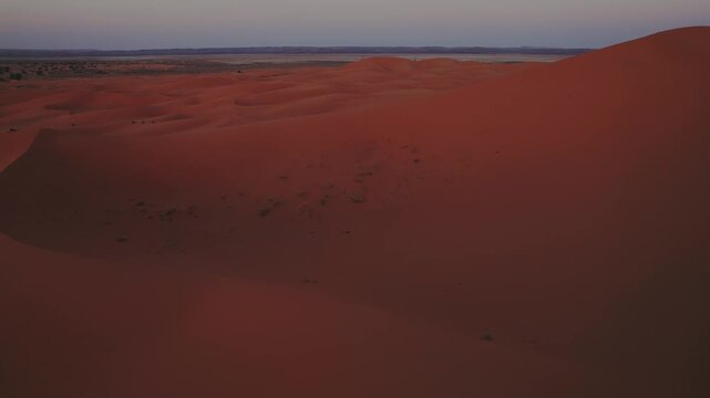 Erg Chebbi dunes extend across the Sahara near Merzouga, Errachidia, Dr&acirc;a-Tafilalet, Morocco, Africa, revealing wind shaped ridges and vast desert terrain, drone forward flyover shot.