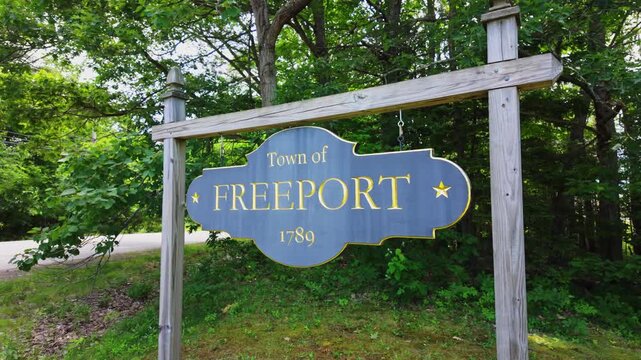 Freeport Maine 1789 signboard framed by dense shadowy forest