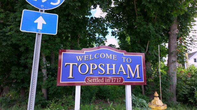 Topsham Maine welcome sign settled in 1717 beside an Interstate 295 marker