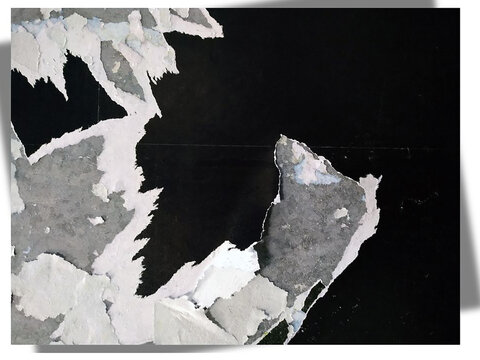 consists of irregular, jagged fragments of off-white and gray material, appearing torn and layered, with subtle hints of blue undertones visible in the crevices.