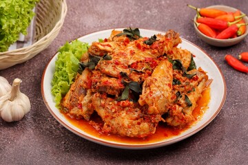 Fototapeta premium Rica-rica or chicken rica-rica, a traditional dish from North Sulawesi made with chicken cooked in a fragrant blend of fresh chilies, garlic, shallots, ginger, lemongrass, and aromatic herbs