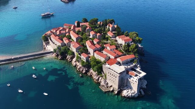 Aerial view of the island of St. Stefan on the Adriatic coast of Montenegro in Mediterranean Sea, showing the coastline and architecture. It is an island resort and popular summer vacation destination