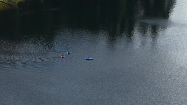 Aerial of recreational kayaks paddling on calm lake in Stevens County in northern Washington in summer