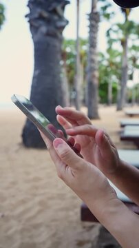 Woman using smartphone on tropical beach, mobile communication and travel lifestyle.