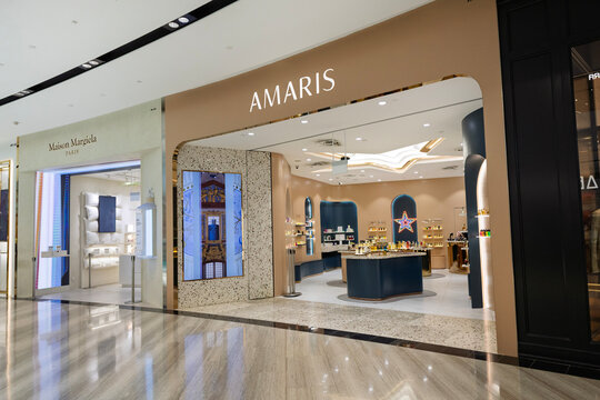 Singapore - January 21, 2026: An eye-level commercial view of the Amaris luxury fragrance storefront and neighboring Maison Margiela boutique inside a modern upscale shopping complex.