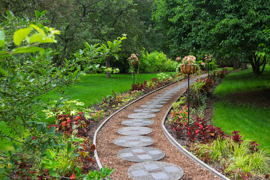 Winding path through lush Dow Gardens summer landscape in Michigan.