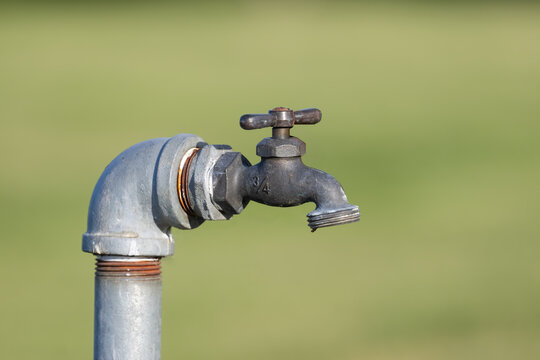 Outdoor garden faucet on stand with green background
