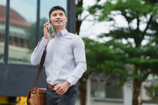 Asian businessman talking on smartphone outdoors