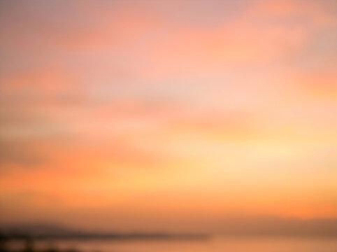 Sunset over calm ocean water with soft pink and orange sky at dusk