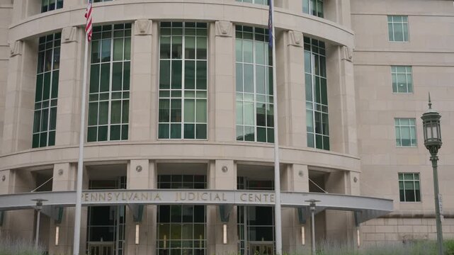Cinematic wide angle push in and tilt up revealing the Pennsylvania Judicial Center in downtown Harrisburg Pennsylvania showcasing modern government architecture and the state judiciary.