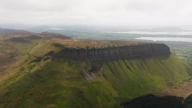 Cinematic drone shot of Ben Bulben table mountain in Sligo, Ireland. Famous flat-topped landmark with green countryside and majestic rock cliffs.