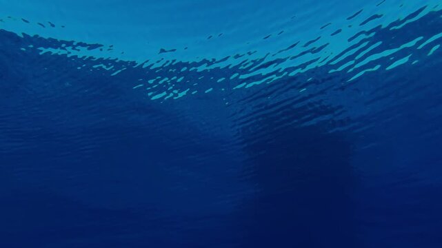 Calm underwater view beneath the ocean surface in Mauritius, featuring blue water gradients and gentle sunlight filtering through. Ideal for marine backgrounds, nature themes, and tranquility concepts
