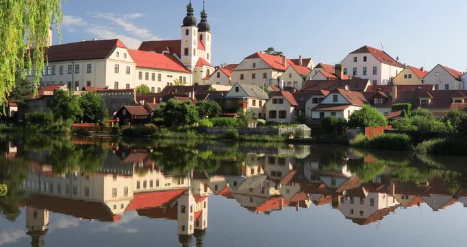 4K  locked off motion view of historic buildings and houses in the pond, the buildings lining the shore of the pond creating a picturesque scene with their reflections in the water, Telc, Europe