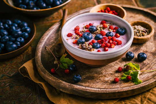 Healthy breakfast yogurt bowl with fresh blueberries and wild strawberries