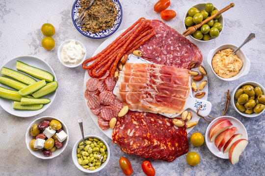 Gourmet charcuterie board with cured meats, olives, dips, and fresh fruit