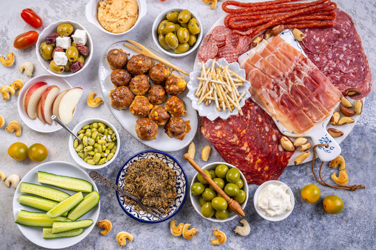 Gourmet charcuterie board with cured meats, olives, dips, and fresh fruit
