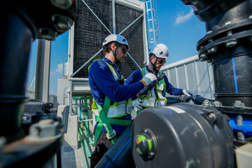 Fototapeta premium HVAC Engineers Inspecting Rooftop Cooling Tower. Industrial Maintenance Operation.