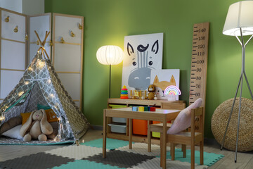 Interior of childrens room with play tent, toys and glowing lamps in evening © Pixel-Shot