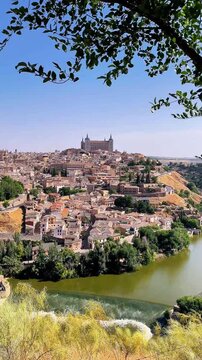 Scenic vertical panorama of Segovia historic city skyline with river and green trees in Spain