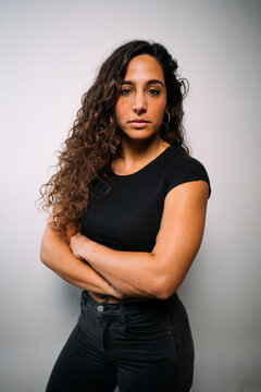 Confident young woman posing with arms crossed