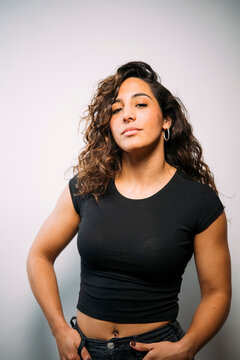 Confident young adult woman with curly hair looking directly