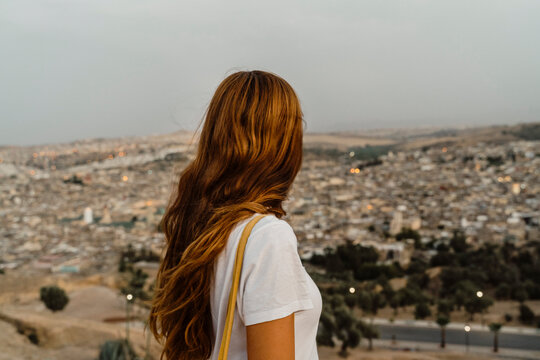 Redheaded woman enjoying city view in the evening, Fez, Morocco