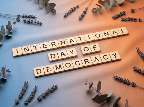 Wooden scrabble tiles spelling international day of democracy surrounded by dried lavender flowers