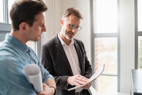 Two colleagues talking at the window in office