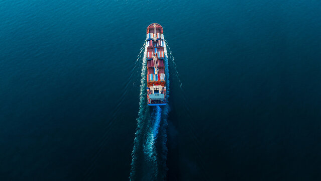 cargo container ship fully loaded transportaion colorful shipping containers navigates through deep blue ocean waters, leaving a wake as it transports goods global maritime logistics 