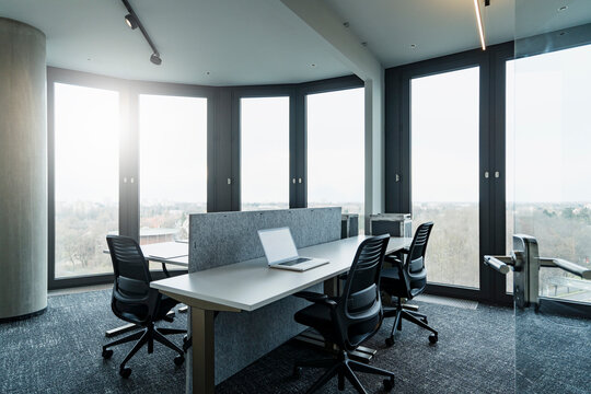 Laptop on desk seen through doorway at modern office