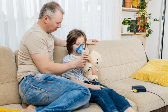 Father comforting child using a nebulizer for asthma at home