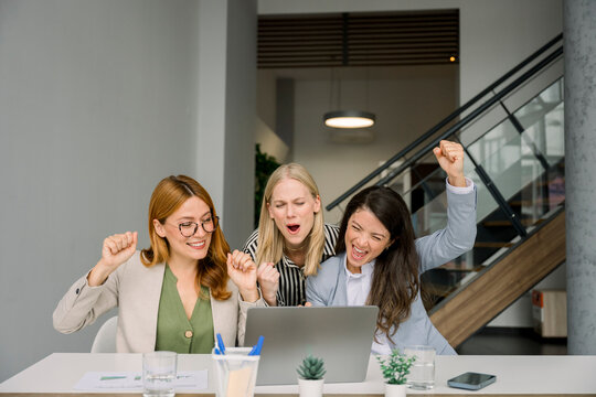 Businesswomen celebrating success and teamwork in modern office