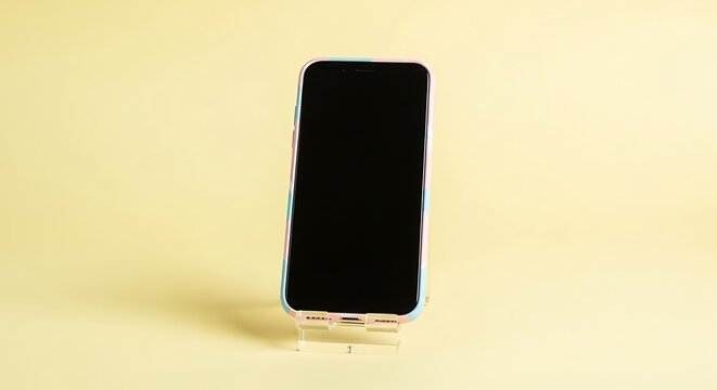 Modern smartphone with a colorful patterned case displayed on a clear stand