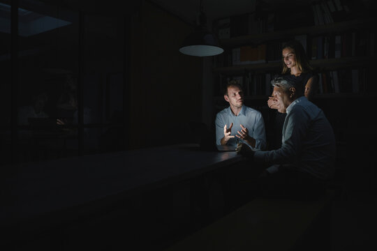Team of business people working late in office, disussing solutions