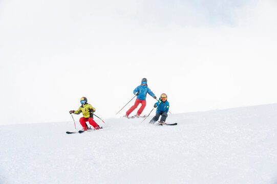 Father and two sons skiing together