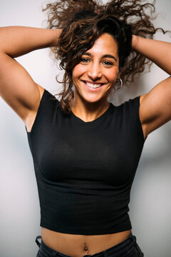 Happy woman smiling holding curly hair embracing confidence