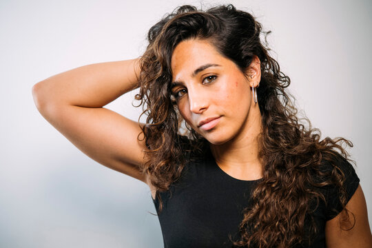 Confident young woman posing with curly hair