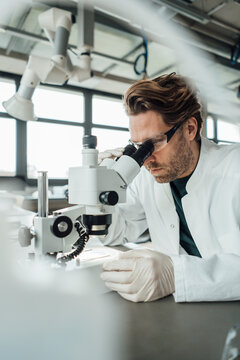 Mature scientist working on microscope in laboratory