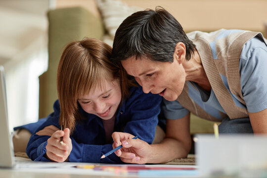 Mother and her daughter with disability drawing at home