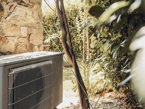 Air conditioner exterior unit in a Tuscany backyard garden