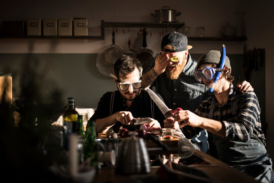 Friends chopping onions with swimming goggles