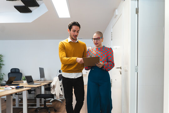Colleagues walking through an office discussing a business plan