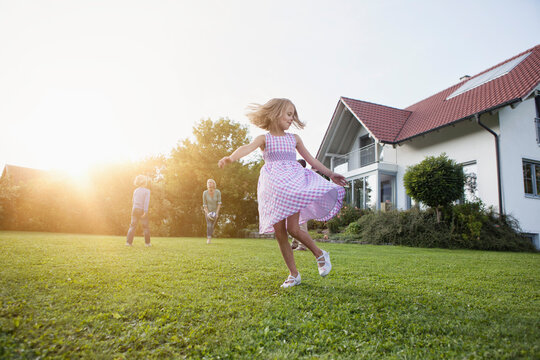 Girl in motion with family in garden