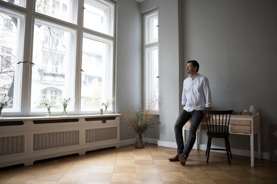 Man looking through window at home