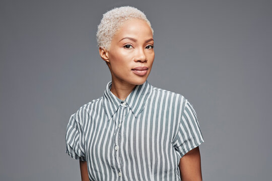 Profile of woman wearing striped blouse in front of grey background
