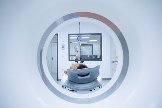 Young doctor with patient at MRI scanner
