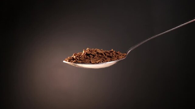 Instant Coffee Granules Falling from Spoon in Slow Motion Macro Close Up