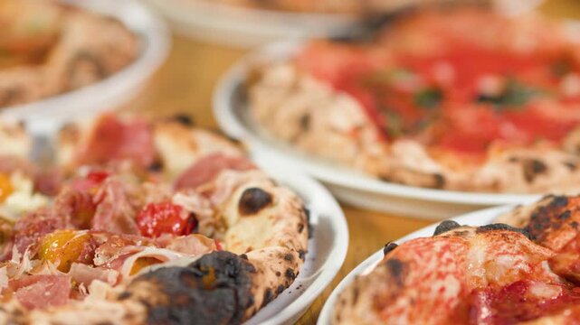 Assorted Neapolitan Style Pizzas on a Wooden Restaurant Table
