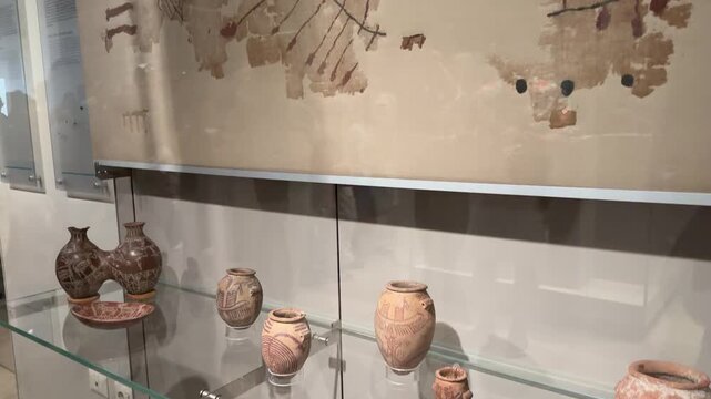 Ancient Pottery and Painted Papyrus Displayed in Museum Glass Case