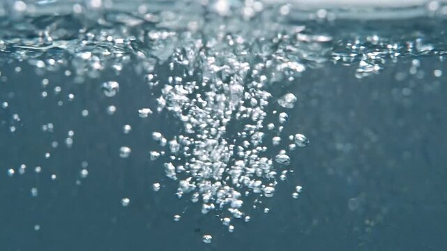 Bubbles Rising Microscopic view of a cascade of tiny air bubbles ascend through clear blue water creating a dynamic pattern of effervescence